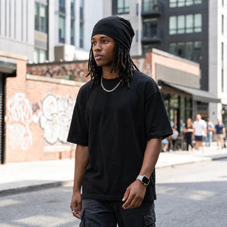 Man with locs wearing the black skull cap in the street