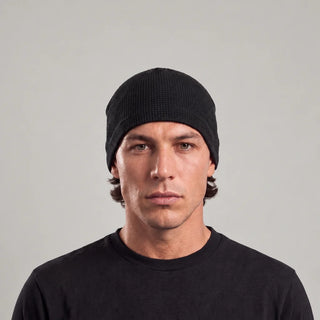 Man wearing the black waffle knit skull cap, front view